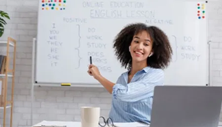 Professeur face à un ordinateur qui pointe un tableau avec écrit un cours d'anglais dessus